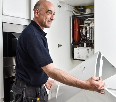 Heating engineer installing a boiler; boiler installation cost