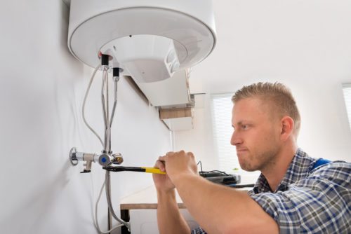 Engineer repairing a boiler; boiler replacement