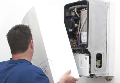 Placing the cover on a boiler as part of a boiler replacement