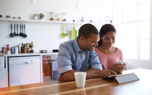 Young couple looking for central heating quotes on a tablet