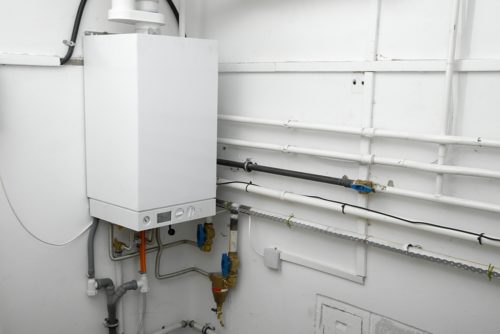 System boiler and pipes in boiler room of a house