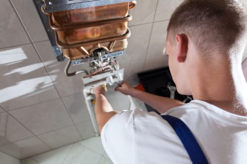 Heating engineer servicing a boiler; boiler service cost