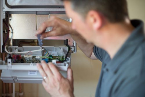 Heating professional checking on a boiler