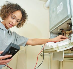 Central heating servicing professional checking on a boiler