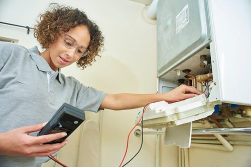 Central heating servicing professional checking on a boiler